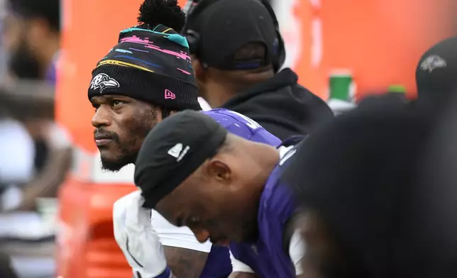 Baltimore Ravens quarterback Lamar Jackson, left, looks out from the bench during the second half of an NFL football game against the Tennessee Titans in Baltimore, Sunday, Oct. 4, 2026. (AP Photo/Nick Wass)