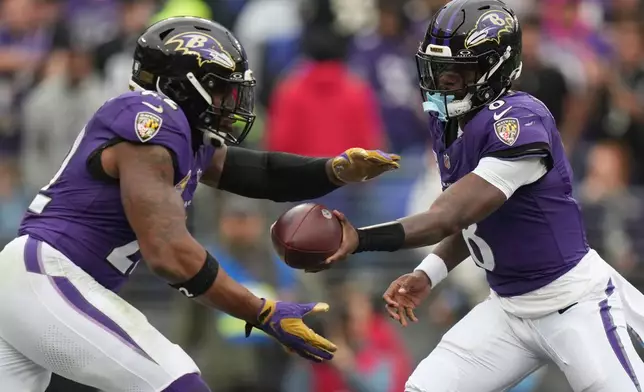 Baltimore Ravens running back Derrick Henry, left, takes a handoff from quarterback Lamar Jackson, right, during the first half of an NFL football game against the Tennessee Titans in Baltimore, Sunday, Oct. 4, 2026. (AP Photo/Stephanie Scarbrough)
