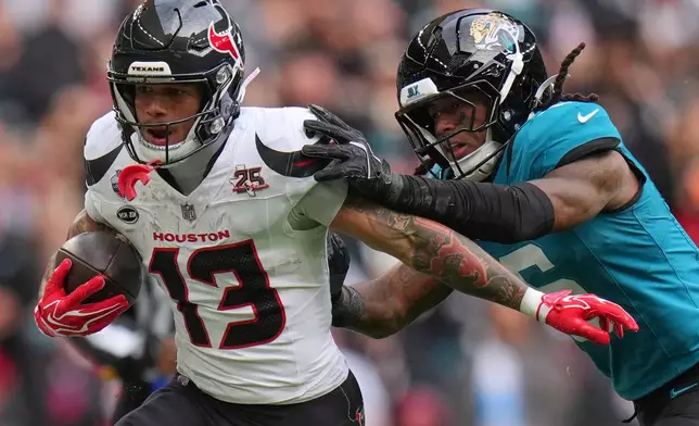Houston Texans wide receiver Jaylin Noel (13) is challenged by Jacksonville Jaguars safety Antonio Johnson (6) during an NFL football game in London, Sunday, Oct. 18, 2026. (AP Photo/Kin Cheung)