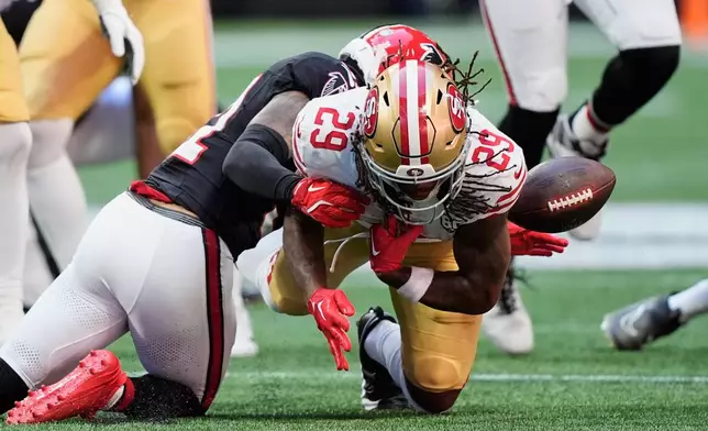 San Francisco 49ers running back Jordan James (29) fumbles the ball after being tackled by Atlanta Falcons' Xavier Watts, left, during the first half of an NFL football game in Atlanta, Sunday, Oct. 25, 2026. (AP Photo/Brynn Anderson)
