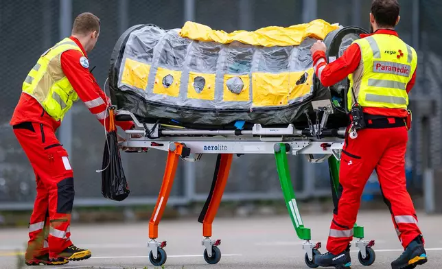 A patient who is suspected to have Ebola is transferred in a isolation unit from a rescue aircraft to a rescue helicopter of Swiss Air Rescue (Rega) at Zurich Airport on Monday, Oct. 26, 2026, in Zurich, Switzerland.(Michael Buholzer/Keystone via AP)