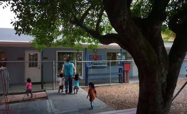 A teacher escorts young children to their classroom at a Head Start preschool in Immokalee, Fla., Thursday, Sept. 10, 2026. (AP Photo/Rebecca Blackwell)