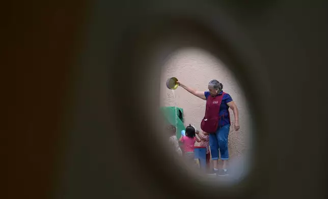 A teacher plays with children at a water table, at a Head Start preschool in Immokalee, Fla., Thursday, Sept. 10, 2026. (AP Photo/Rebecca Blackwell)