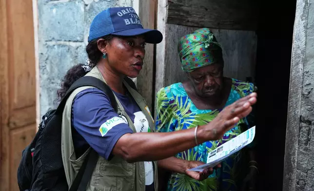 A worker educates a resident ahead of the spraying exercise to help prevent the spread of malaria in Malabo, Equatorial Guinea, April 24, 2026. (AP Photo/Misper Apawu)