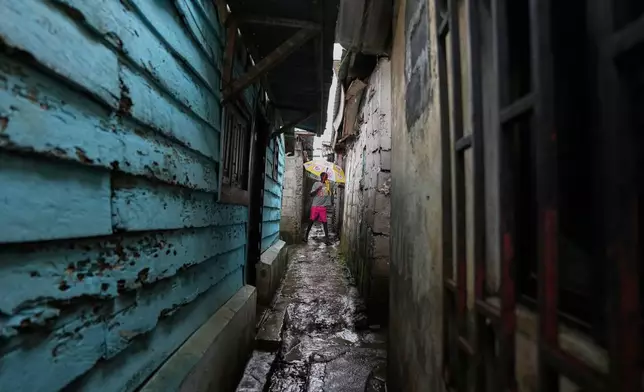 A resident walks through a narrow alley in a neighbourhood where MCD Global Health workers are spraying insecticide to help prevent the spread of malaria in Malabo, Equatorial Guinea, April 24, 2026. (AP Photo/Misper Apawu)