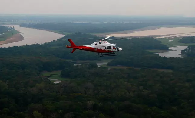 FILE - A helicopter from Brazil's environmental agency flies over an area of the Amazon rainforest during a wildfire-fighting operation in Autazes, Amazonas state, Brazil, Oct. 15, 2026. (AP Photo/Edmar Barros, File)