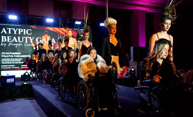 Models accompany wheelchair using models on a catwalk practice run during the Atypic Beauty Gala fashion show, an event promoting inclusion and equal opportunities for people with disabilities, in Bucharest, Romania, Thursday, Oct. 22, 2026. (AP Photo/Andreea Alexandru)