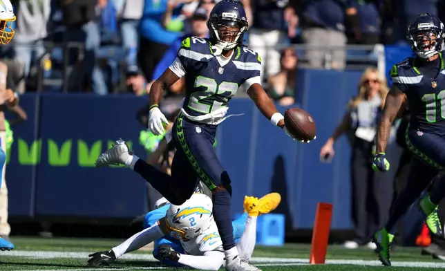 Seattle Seahawks wide receiver Rashid Shaheed (22) scores a touchdown over Los Angeles Chargers cornerback Elijah Molden (2) during the first half of an NFL football game, Sunday, Oct. 4, 2026, in Seattle. (AP Photo/Lindsey Wasson)