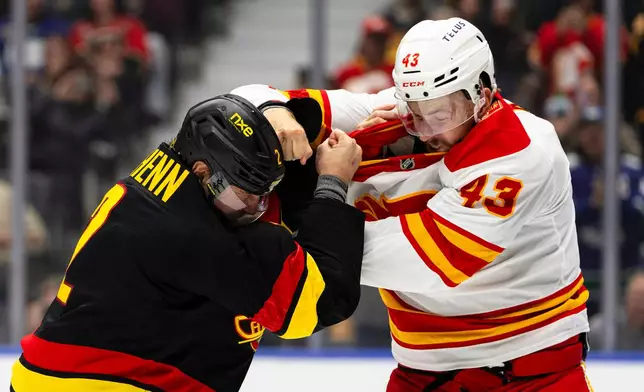 Vancouver Canucks' Luke Schenn (2) and Calgary Flames' Adam Klapka (43) fight during the first period of an NHL hockey game in Vancouver, British Columbia, Saturday, Oct. 3, 2026. (Jacob Mallari/The Canadian Press via AP)