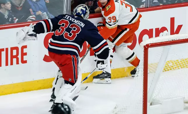 Winnipeg Jets goaltender Clay Stevenson (33) gets caught out of his net as Anaheim Ducks' Jeff Malott (39) makes a pass during the second period of an NHL hockey game in Winnipeg, Manitoba, Friday, Oct. 9, 2026. (John Woods/The Canadian Press via AP)