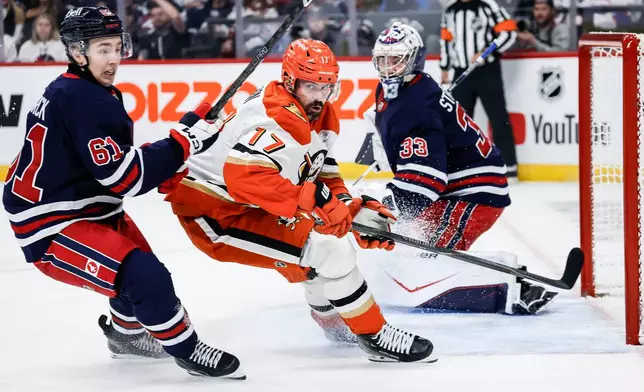Winnipeg Jets' Viggo Bjorck (61) defends against Anaheim Ducks' Alex Killorn (17) in front of Jets goaltender Clay Stevenson (33) during the first period of an NHL hockey game in Winnipeg, Manitoba, Friday, Oct. 9, 2026. (John Woods/The Canadian Press via AP)