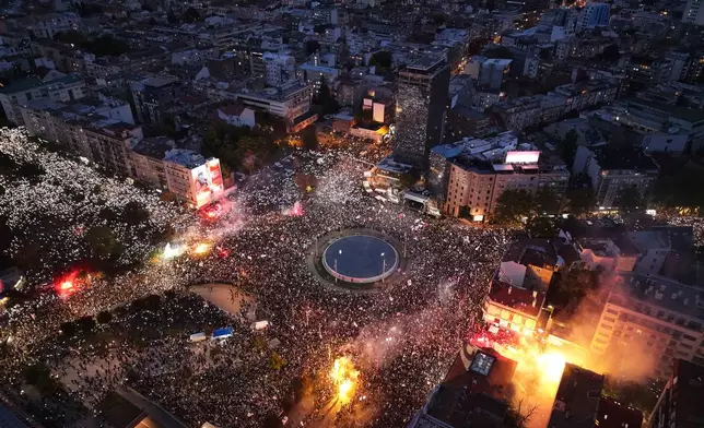 People shine the lights of they mobile phones and light flares during the final "Student List – Students Win" rally ahead of a parliamentary election in Belgrade, Serbia, Thursday, Oct. 22, 2026. (AP Photo/Armin Durgut)