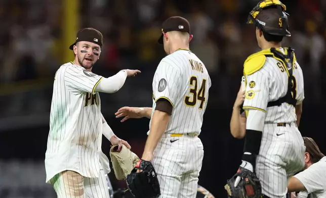 San Diego Padres' Jackson Merrill, left, Michael King and Ethan Salas, right, celebrate a victory over the Milwaukee Brewers in Game 3 of baseball's National League Division Series Tuesday, Oct. 6, 2026, in San Diego. (AP Photo/Derrick Tuskan)
