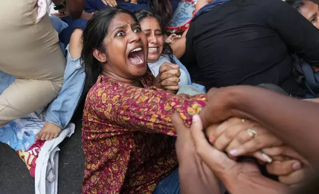 A woman is detained by police during a protest demanding the resignation of the country's election chief, Gyanesh Kumar, in Mumbai, India, Sunday, Oct. 11, 2026. (AP Photo/Rafiq Maqbool)