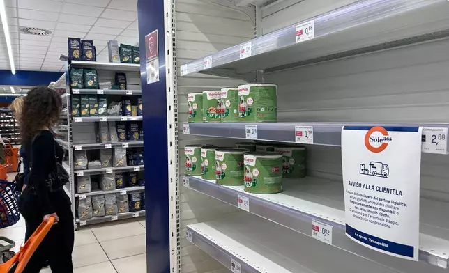 A notice on empty shelves at a supermarket apologizes to customers for the lack of products, due to an ongoing truckers strike in Naples, Italy, Tuesday, Oct. 20, 2026. (AP Photo/Alessandra Tarantino)