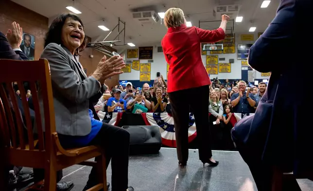 FILE - Labor leader Dolores Huerta, left, applauds on stage as Democratic presidential candidate Hillary Clinton speaks during a campaign event at Carl Hayden Community High School in Phoenix, March 21, 2016. (AP Photo/Carolyn Kaster, File)