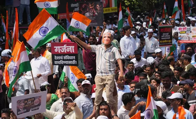 A protester wears a mask depicting Chief Election Commissioner Gyanesh Kumar with the words "vote theft" during a protest organized by Shiv Sena (UBT) and the Maharashtra Navnirman Sena , demanding his resignation and the suspension of the Special Intensive Revision (SIR) of electoral rolls, in Mumbai, India, Sunday, Oct. 4, 2026.(AP Photo/Rafiq Maqbool)