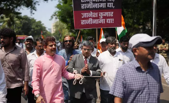 A protester dressed as Chief Election Commissioner Gyanesh Kumar arrives with his hands tied during a protest organized by Shiv Sena (UBT) and the Maharashtra Navnirman Sena (MNS), demanding Kumar's resignation and the suspension of the Special Intensive Revision (SIR) of electoral rolls, in Mumbai, India, Sunday, Oct. 4, 2026.(AP Photo/Rafiq Maqbool)