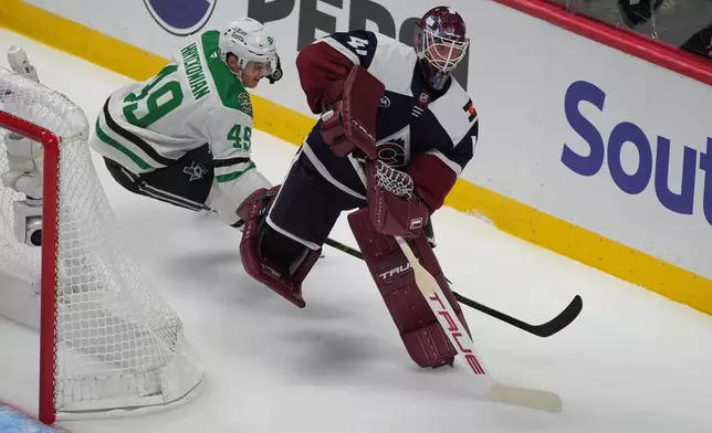 Colorado Avalanche goaltender Scott Wedgewood, front, clears the puck as Dallas Stars center Justin Hryckowian covers in the first period of an NHL hockey game Wednesday, Oct. 14, 2026, in Denver. (AP Photo/David Zalubowski)