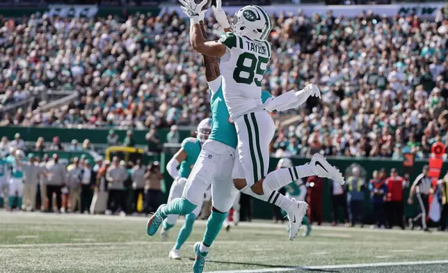 New York Jets tight end Mason Taylor (85) catches a pass for a touchdown as Miami Dolphins cornerback Jason Marshall Jr., left, defends in the first half of an NFL football game against the Miami Dolphins in East Rutherford, N.J., Sunday, Oct. 25, 2026. (AP Photo/Adam Hunger)