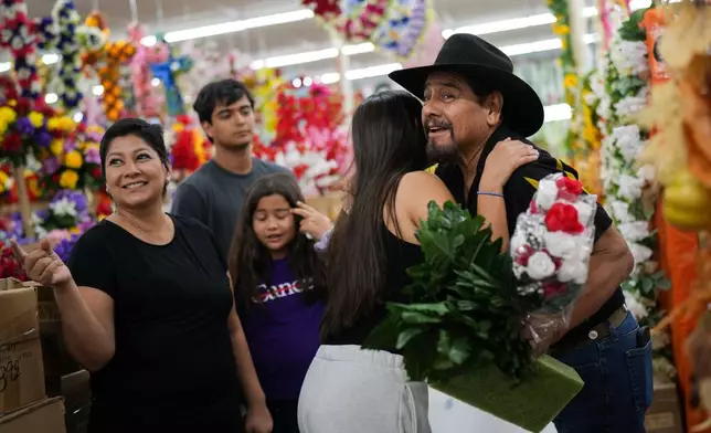Fidel Banda, right, is greeted by his grandchildren, Kimberly Ford, from right, Kathryn Shergold, center, Joey Leal III, rear, and daughter Cindy Banda, at Floreria Lee as they shop for flowers before visiting the tomb of his daughter, Melissa Banda, Sept. 14, 2026, in McAllen, Texas. (AP Photo/Julia Demaree Nikhinson)