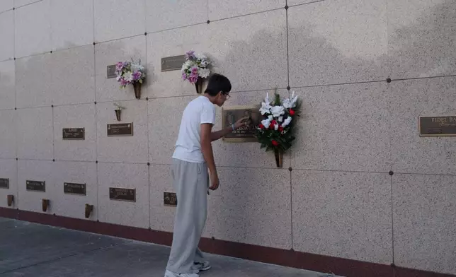 Richard "Trey" Ford III touches his mother's tomb plate at Funeraria del Angel Highland Funeral Home and Memorial Park, Sept. 15, 2026, in Weslaco, Texas. (AP Photo/Julia Demaree Nikhinson)