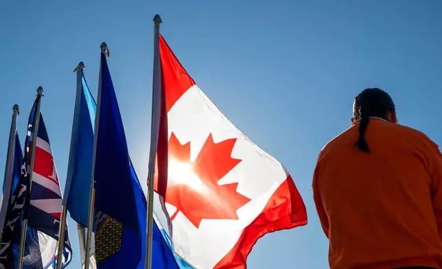 Flags fly at the National Day for Truth and Reconciliation event, Wednesday Sept. 30, 2026, in Edmonton, Alberta. (John Ulan/The Canadian Press via AP)