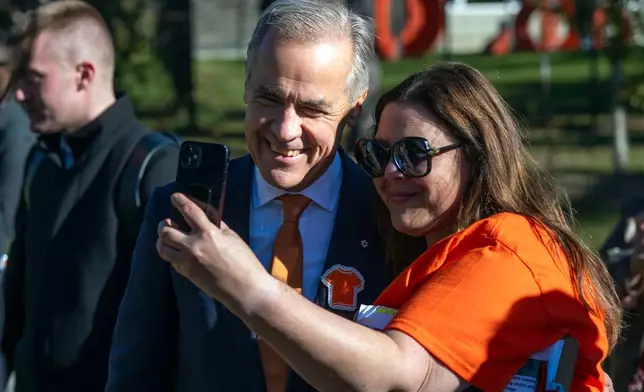 Canada Prime Minister Mark Carney, left, poses at the National Day for Truth and Reconciliation event, Wednesday Sept. 30, 2026, in Edmonton, Alberta. (John Ulan/The Canadian Press via AP)