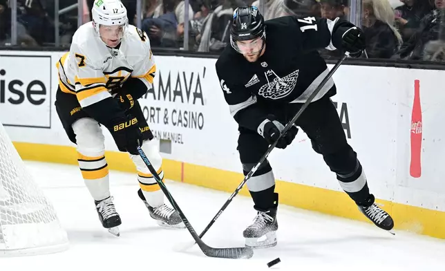 Los Angeles Kings right wing Alex Laferriere (14) takes control of the puck against Boston Bruins defenseman Will Borgen (17) during the second period of an NHL hockey game Saturday, Oct. 17, 2026, in Los Angeles. (AP Photo/Wally Skalij)