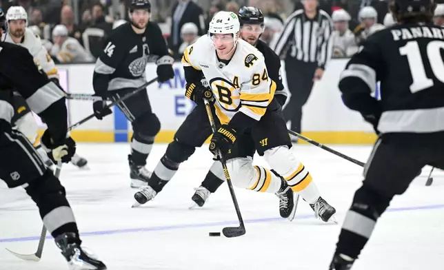 Boston Bruins left wing Tanner Jeannot (84) takes the puck up the ice between Los Angeles Kings defenders during the first period of an NHL hockey game Saturday, Oct. 17, 2026, in Los Angeles. (AP Photo/Wally Skalij)