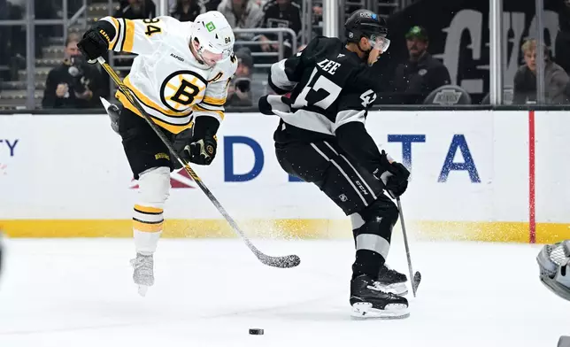 Boston Bruins left wing Tanner Jeannot (84) battles for the puck against Los Angeles Kings left wing Andre Lee (47) during the first period of an NHL hockey game Saturday, Oct. 17, 2026, in Los Angeles. (AP Photo/Wally Skalij)