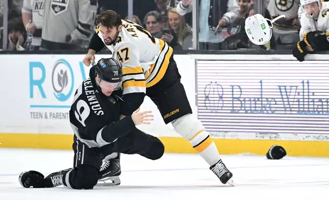 Boston Bruins center Mark Kastelic (47) fights with Los Angeles Kings center Samuel Helenius (79) during the first period of an NHL hockey game Saturday, Oct. 17, 2026, in Los Angeles. (AP Photo/Wally Skalij)
