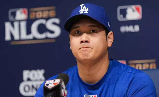 Los Angeles Dodgers' Shohei Ohtani listens to questions from the media during a news conference ahead of Game 3 of baseball's National League Championship Series against the Milwaukee Brewers, Tuesday, Oct. 13, 2026, in Los Angeles. (AP Photo/Jae C. Hong)