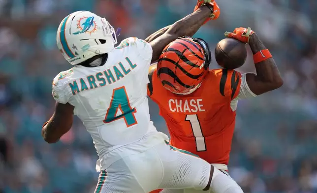Cincinnati Bengals wide receiver Ja'marr Chase (1) catches a pass for a touchdown as Miami Dolphins cornerback Jason Marshall Jr. (4) defends during the second half of an NFL football game in Miami Gardens, Fla., Sunday, Oct. 11, 2026. (AP Photo/Rebecca Blackwell)