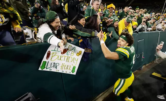 Green Bay Packers wide receiver Christian Watson (9) celebrates with fans after winning an NFL football game against the Carolina Panthers in Green Bay, Wis., Thursday, Oct. 29, 2026. (AP Photo/Mike Roemer)