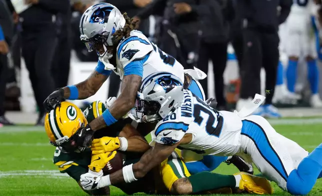 Green Bay Packers wide receiver Christian Watson, left, is tackled by Carolina Panthers cornerback Will Lee III, top, and Zakee Wheatley, Lee and Watson were injured on the play, during the first half of an NFL football game in Green Bay, Wis., Thursday, Oct. 29, 2026. (AP Photo/Mike Roemer)