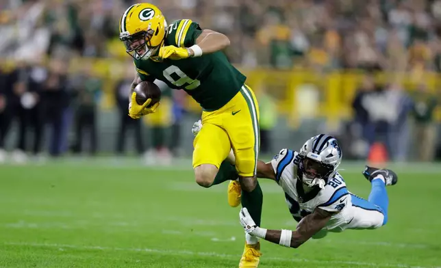 Green Bay Packers wide receiver Christian Watson (9) is hit by Carolina Panthers safety Zakee Wheatley as he catches a pass for a first down during the first half of an NFL football game in Green Bay, Wis., Thursday, Oct. 29, 2026. (AP Photo/Matt Ludtke)