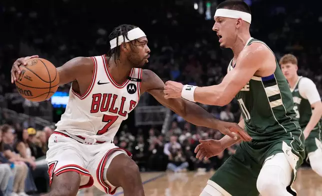 Chicago Bulls guard Buddy Hield, left, drives against Milwaukee Bucks guard Tyler Herro, right, during the first half of an NBA basketball game Friday, Oct. 23, 2026, in Milwaukee. (AP Photo/Nam Y. Huh)