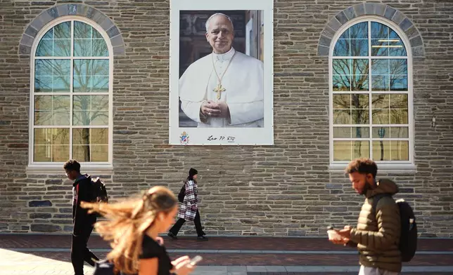 Students walk past an image of Pope Leo XIV at Villanova University in Villanova, Pa., Wednesday, Oct. 21, 2026. (AP Photo/Matt Rourke)