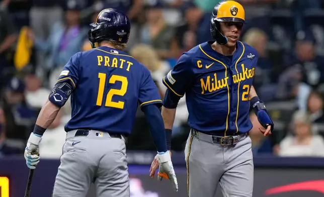 Milwaukee Brewers designated hitter Christian Yelich celebrates scoring with shortstop Cooper Pratt (12) off a base hit by second baseman Brice Turang during the fifth inning of Game 3 of baseball's World Series, Monday, Oct. 26, 2026, in St. Petersburg, Fla., between the Milwaukee Brewers and the Tampa Bay Rays. (AP Photo/Chris O'Meara)