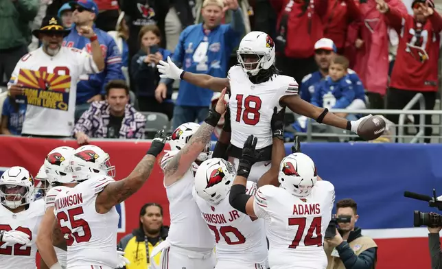 Arizona Cardinals wide receiver Marvin Harrison Jr. (18) celebrates his touchdown catch against the New York Giants with Cardinals guard Isaiah Adams (74), offensive tackle Paris Johnson Jr. (70) and offensive tackle Elijah Wilkinson (65) during an NFL football game, in East Rutherford, N.J., Sunday, Oct. 4, 2026. (AP Photo/Adam Hunger)