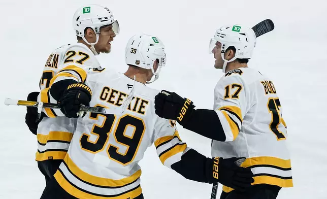 Boston Bruins' Hampus Lindholm (27), Morgan Geekie (39) and William Borgen (17) celebrate Lindholm's goal against the Winnipeg Jets during the first period of an NHL hockey game in Winnipeg, Manitoba, Friday, Oct. 2, 2026. (John Woods/The Canadian Press via AP)