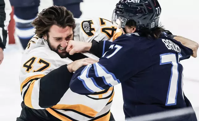 Winnipeg Jets' Tyrel Bauer (77) and Boston Bruins' Mark Kastelic (47) fight during the first period of an NHL hockey game in Winnipeg, Manitoba, Friday, Oct. 2, 2026. (John Woods/The Canadian Press via AP)