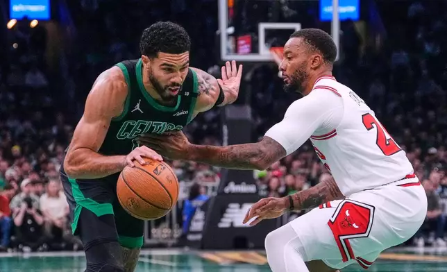 Boston Celtics' Jayson Tatum, left, drives to the basket against Chicago Bulls' Norman Powell, right, during the first half of an NBA Cup basketball game, Friday, Oct. 30, 2026, in Boston. (AP Photo/Charles Krupa)