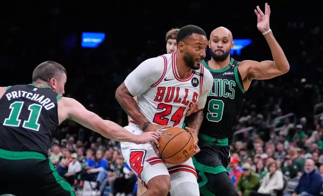 Chicago Bulls' Norman Powell (24) is pressured by Boston Celtics' Payton Pritchard (11) and Derrick White (9) on a drive to the basket during the first half of an NBA Cup basketball game, Friday, Oct. 30, 2026, in Boston. (AP Photo/Charles Krupa)