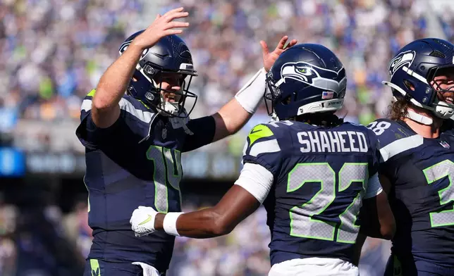 Seattle Seahawks wide receiver Rashid Shaheed (22) celebrates with teammate quarterback Sam Darnold (14) after scoring a touchdown during the first half of an NFL football game against the Los Angeles Chargers, Sunday, Oct. 4, 2026, in Seattle. (AP Photo/Lindsey Wasson)