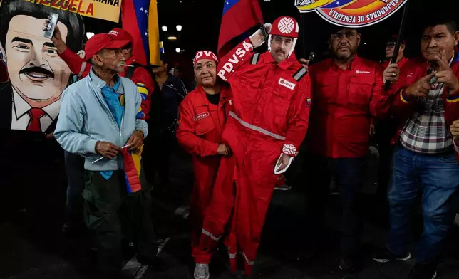 FILE - A PDVSA worker of the state-owned oil company carries a cutout of former President Nicolas Maduro dressed as an oil worker during a rally to back an oil reform bill proposed by acting President Delcy Rodriguez to loosen state control and open the industry to private and foreign investment in Caracas, Venezuela, Jan. 29, 2026. (AP Photo/Ariana Cubillos, File)