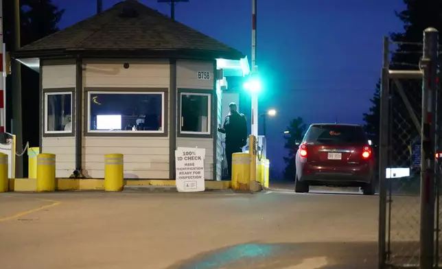 In this photo taken with a smart phone, a car drives through a security booth at the entrance to Canadian Forces Base Wainwright in Alberta, Canada, Monday, Oct. 18, 2026. (AP Photo/Ty O'Neil)