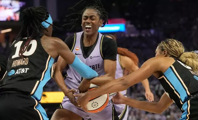 Golden State Valkyries guard Tiffany Hayes, middle, holds onto the ball against Atlanta Dream guard Rhyne Howard (10) and forward Naz Hillmon during the first half of Game 5 of the WNBA basketball finals, Monday, Oct. 26, 2026, in San Francisco. (AP Photo/Jeff Chiu)