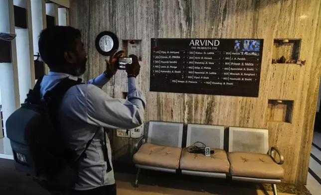 News media personnel film in the building where relatives of Smit Machchhar, an Indian pilot for Flydubai, previously lived in Mumbai, India, Thursday, Oct. 1, 2026. (AP Photo/Rafiq Maqbool)